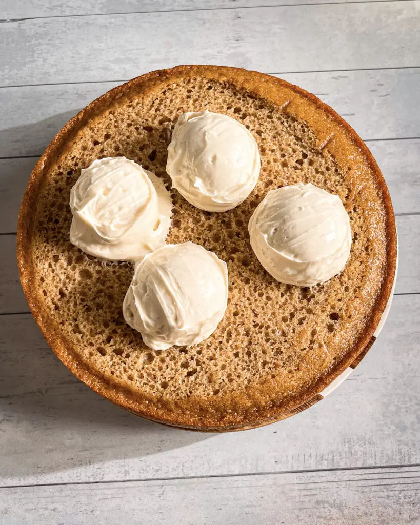 Cinnamon buttercream spread over apple pie cake
