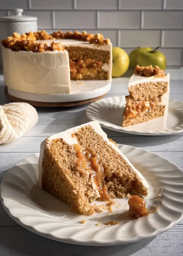 Slice of apple pie cake showing cinnamon cake and apple filling