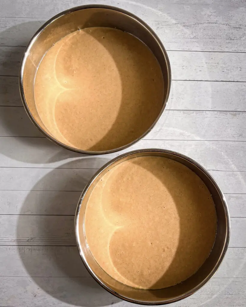 Cinnamon cake batter divided between two 8-inch cake pans