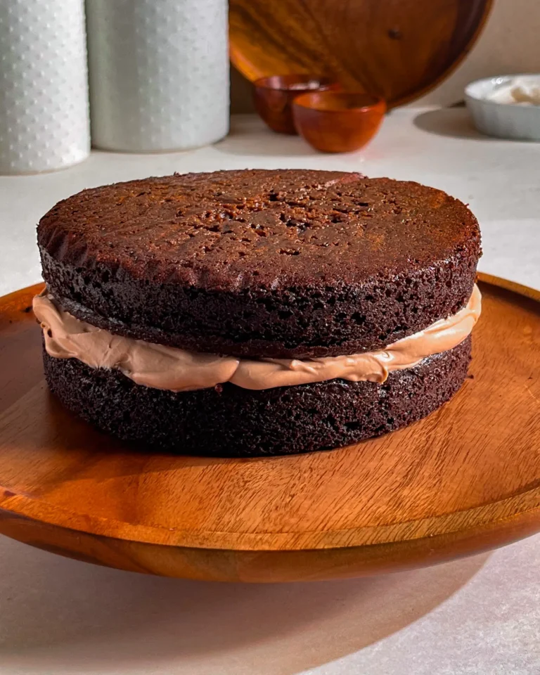 small chocolate cake with milk chocolate whipped ganache on a cake stand