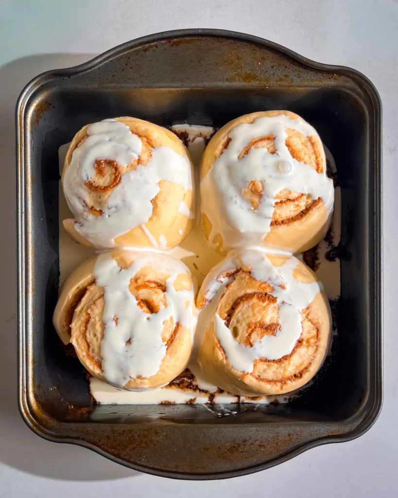 pouring cream on small batch cinnamon rolls eggless and dairyfree